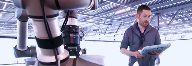 Engineer operates a robotic arm via his tablet computer