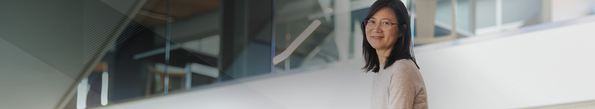 Woman sitting in modern building looking at camera