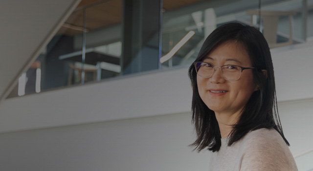 Woman sitting in modern building looking at camera