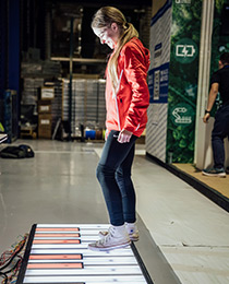 student on a giant floor piano