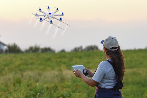 a woman controling a drown in an open grass field