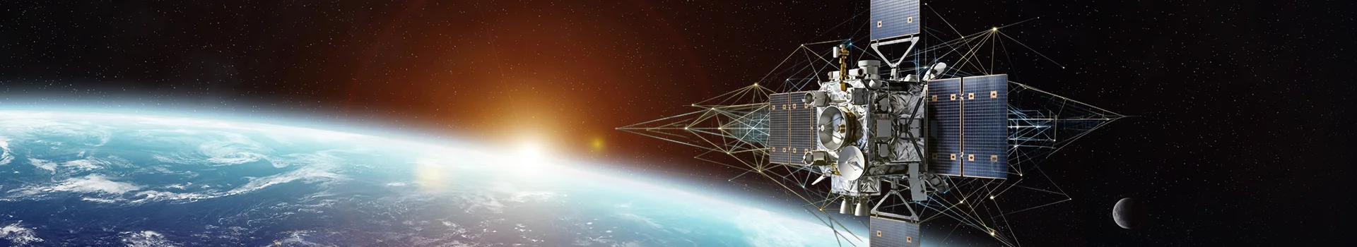 Satellite with solar panels in orbit above Earth at dawn.