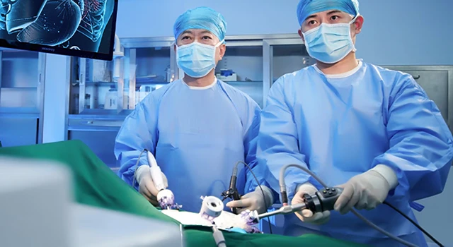 Surgeons in blue scrubs and masks performing laparoscopic surgery.