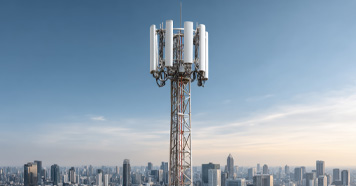 Cellular communication tower overlooking a modern city, symbolizing mobile network infrastructure.