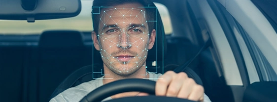 Facial recognition tracking a man driving.