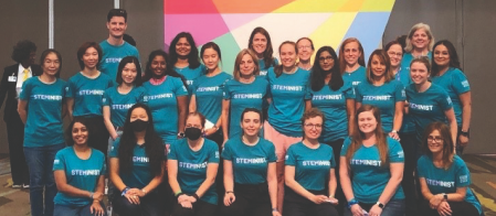 A photo of three rows of analog employees wearing green Steminist t-shirts