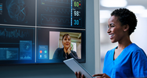 Graphic image shows a female nurse reviewing medical data on a tablet and on a large screen TV panel.