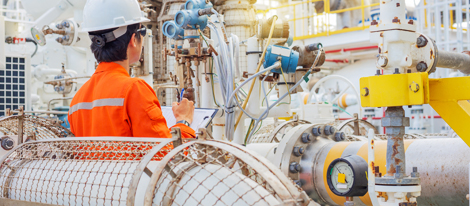 Engineer in hardhat monitoring flow meters at a plant.