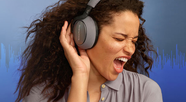 Woman signing while wearing headphones and an audio signal graphic displays in the background.