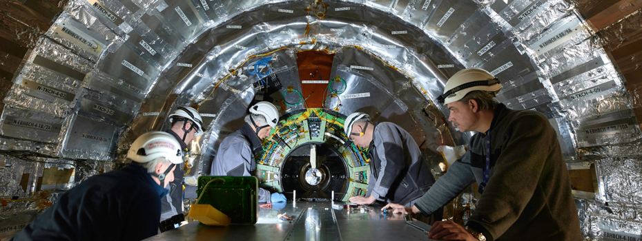 Image displays several people working on precision instruments for CERN's technology.
