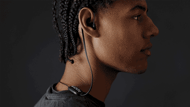 Person wearing black neckband earbuds.