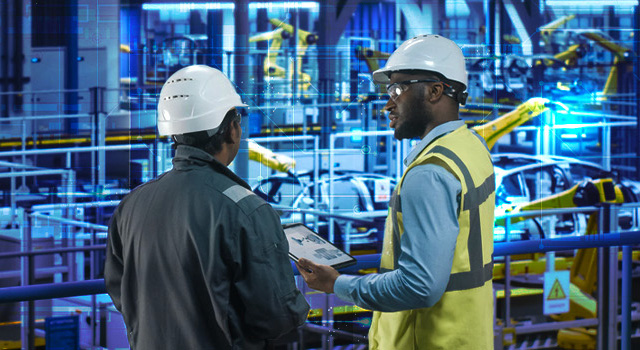 An image of a factory car assembly line with factory workers reviewing documents