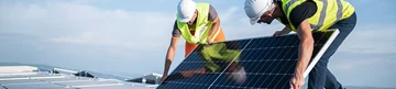 Worker operates equipment at power station, another works on overhead lines. Worker operates equipment at power station, another works on overhead lines.