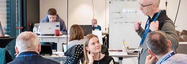 Team with laptops engage in an animated discussion