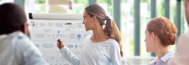 Leader discusses whiteboard diagram with a group