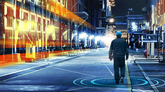 Worker walks through chemical factory corridor