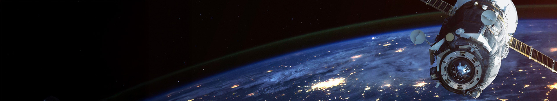 Satellite orbiting Earth with illuminated city lights and atmospheric glow in space view