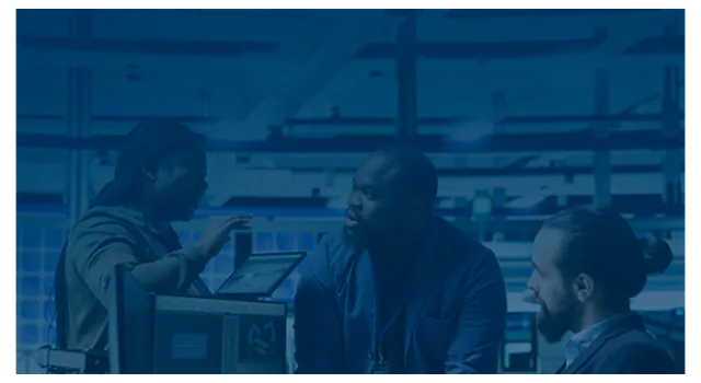 Three engineers discussing data in a server room.