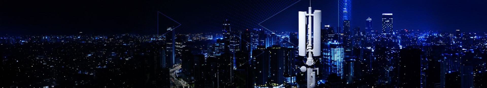 A rooftop cellular antenna overlooking a brightly lit city skyline at night.