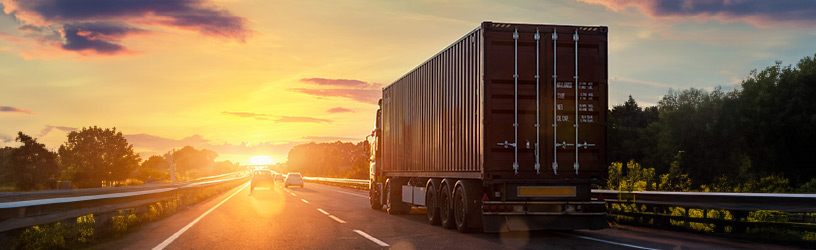A semi-trailer truck riding on a highway