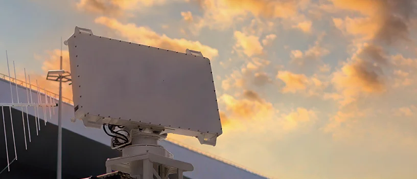 Two octagonal radar dishes against a stormy sunset sky.