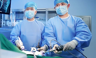 Surgeons in blue scrubs and masks performing laparoscopic surgery.