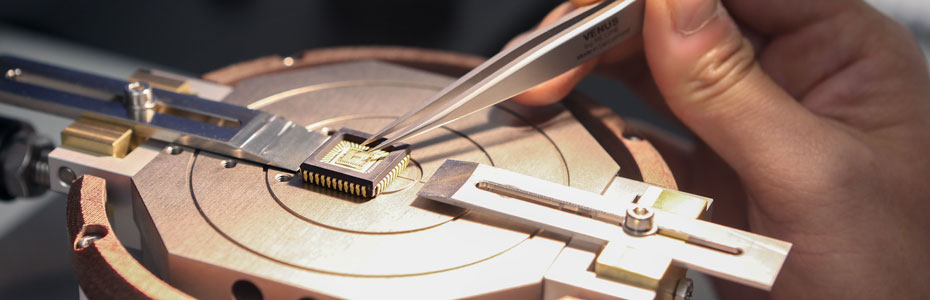 Zoomed in view of a microchip being adjusted with tweezers