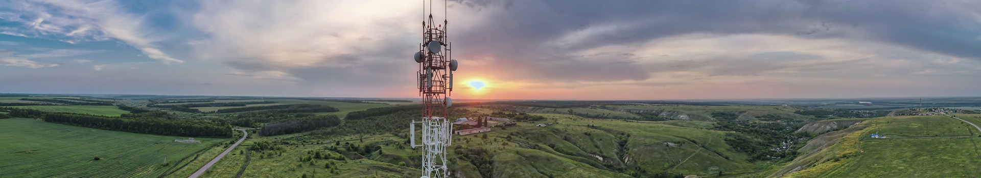Panoramic view of telecommunications tower overlooking rural landscape at sunset