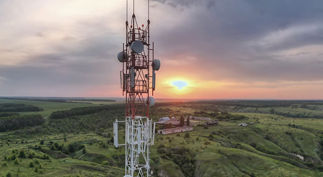 Panoramic view of telecommunications tower overlooking rural landscape at sunset