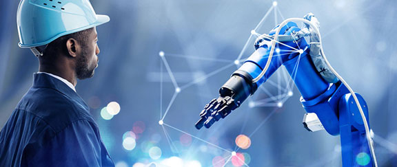 Person in blue safety helmet observing robotic arm in high-tech industrial setting.