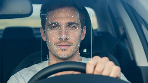 Facial recognition tracking a man driving.