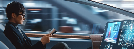 Man reading in autonomous car; screen shows map and news.