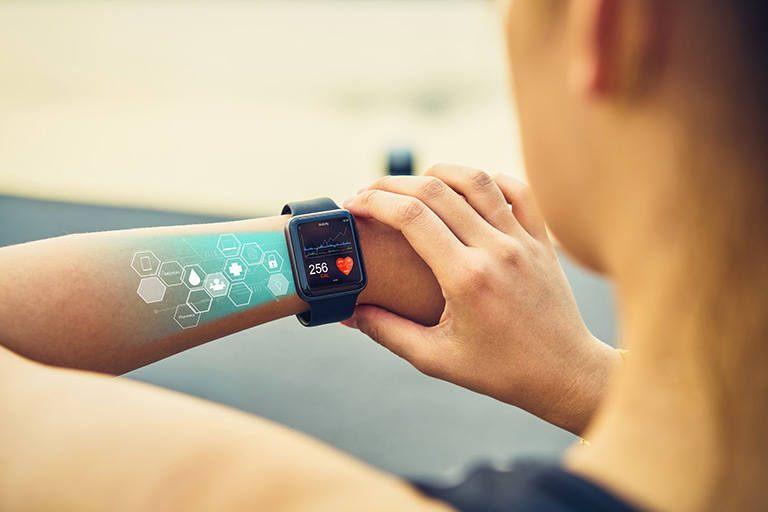 Arm with smartwatch displaying health data and holographic icons.