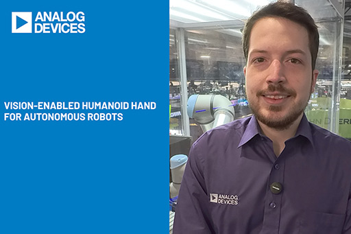 Person in a robotics lab beside a display reading ‘Vision‑Enabled Humanoid Hand for Autonomous Robots.