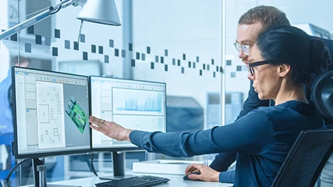 Two engineers designing a circuit board on CAD software.