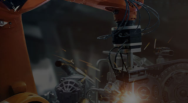 Robotic arm welds in a machine factory
