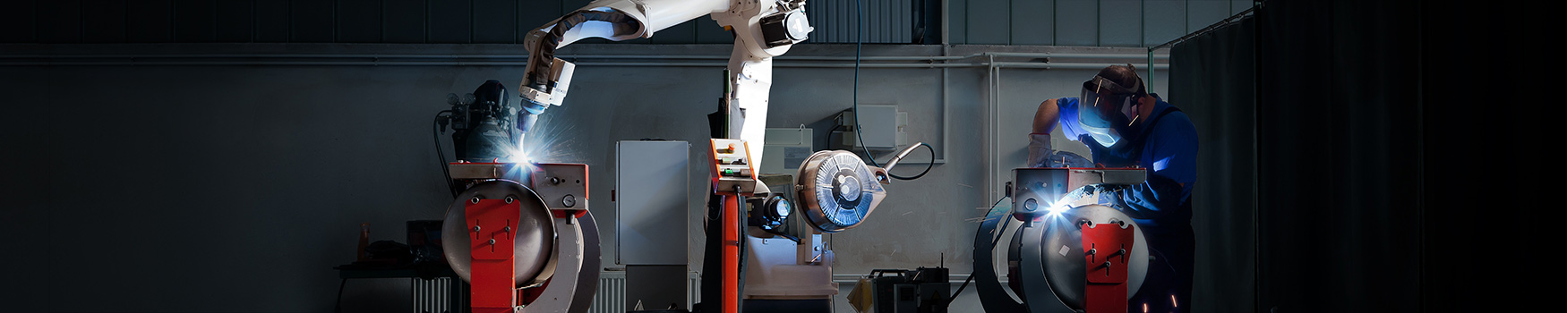 Cobot and welder working side-by-side in a dark room